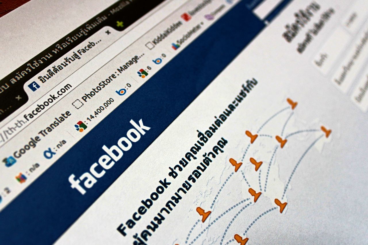 services-01 Close-up view of a Facebook webpage displayed on a browser with social media icons.